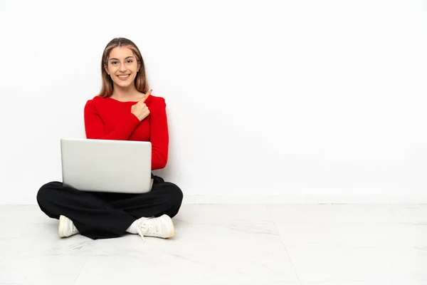 Young Caucasian Woman Laptop Sitting Floor Pointing Side Present Product — Foto Stock