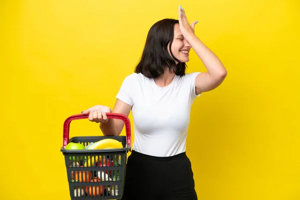 Mladá Žena Drží Nákupní Košík Plný Potravin Izolovaných Žlutém Pozadí — Stock fotografie
