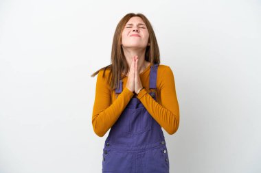 Beyaz arka planda izole edilmiş genç İngiliz kadın avuç içlerini bir arada tutuyor. İnsan bir şey ister.