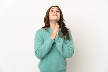 Beyaz arka planda izole edilmiş küçük beyaz kız avuç içlerini bir arada tutuyor. İnsan bir şey ister.