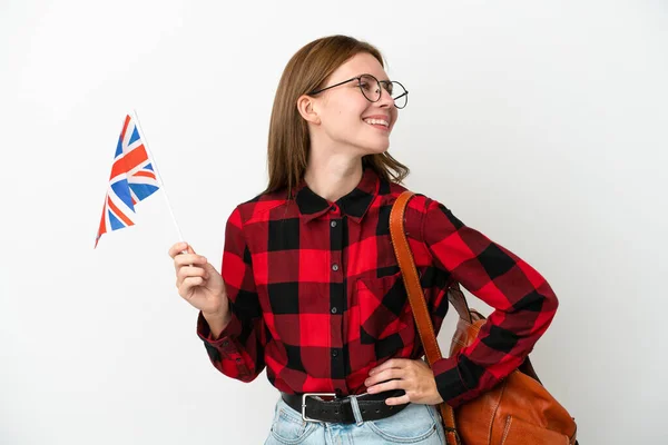 拿着英国国旗的年轻女子 蓝色背景 双臂叉腰 面带微笑 — 图库照片