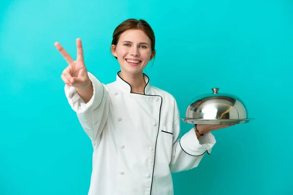 Junge Köchin Mit Tablett Auf Blauem Hintergrund Lächelt Und Zeigt — Stockfoto