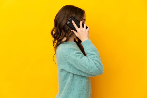 Маленькая Кавказская Девочка Изолированная Желтом Фоне Разговаривает Кем Мобильному Телефону — стоковое фото