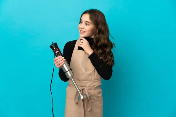 Menina Usando Liquidificador Mão Isolado Fundo Azul Olhando Para Cima — Fotografia de Stock