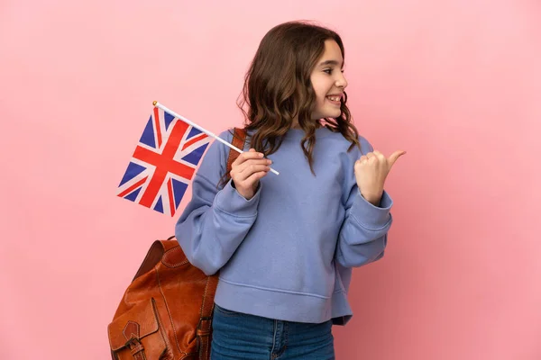 Menina Segurando Uma Bandeira Reino Unido Isolada Fundo Rosa Apontando — Fotografia de Stock