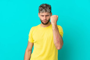 Mutsuz bir ifadeyle mavi arka planda izole edilmiş yakışıklı beyaz bir adam.