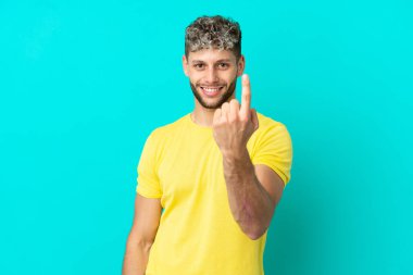 Mavi arka planda soyutlanmış yakışıklı beyaz bir adam geliyor.