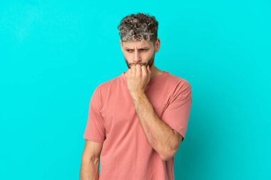 Mavi arka planda izole edilmiş yakışıklı beyaz adam kuşkuları var.