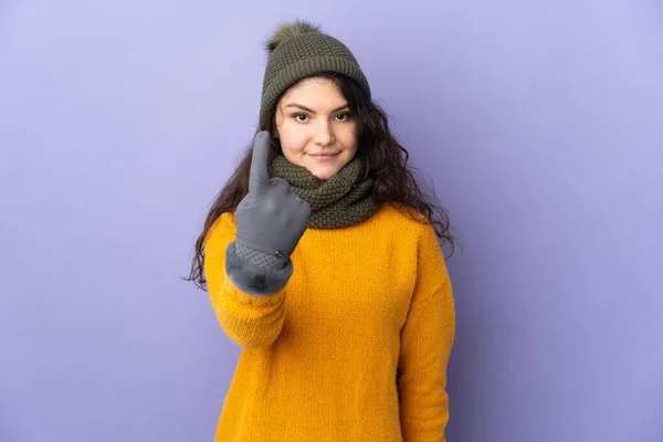 俄罗斯少女 头戴紫色背景的冬帽 做着即将到来的姿势 — 图库照片