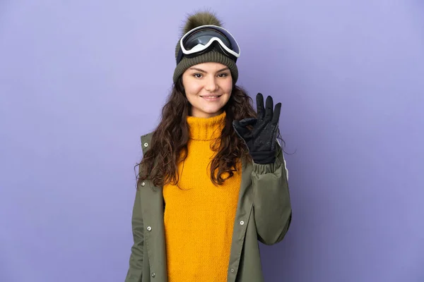 俄罗斯少女 戴着雪板眼镜 与紫色背景隔离 手指上有可控标志 — 图库照片