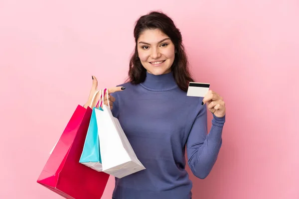 Tiener Russisch Meisje Geïsoleerd Roze Achtergrond Holding Boodschappentassen Een Creditcard — Stockfoto