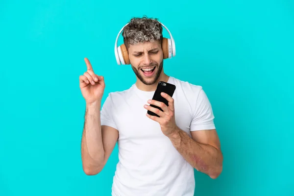 Jovem Bonito Caucasiano Homem Isolado Azul Fundo Ouvir Música Com — Fotografia de Stock