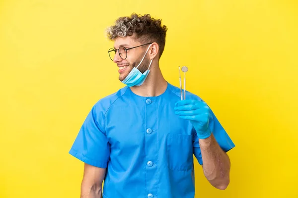 Dentist Caucasian Man Holding Tools Isolated Yellow Background Looking Side — 스톡 사진