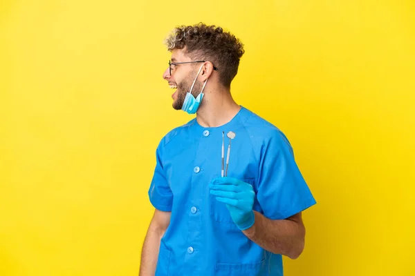 Dentist Caucasian Man Holding Tools Isolated Yellow Background Laughing Lateral — Fotografia de Stock