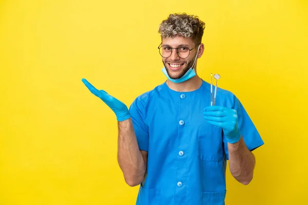 Dentysta Kaukaski Mężczyzna Trzymając Narzędzia Izolowane Żółtym Tle Wyciągając Ręce — Zdjęcie stockowe