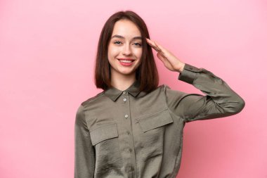 Genç Ukraynalı kadın pembe arka planda izole edilmiş, mutlu bir ifadeyle selamlanıyor.