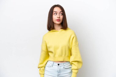 Beyaz arka planda izole edilmiş genç Ukraynalı kadın şüpheli hareketler yapıyor.