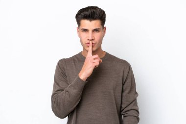 Beyaz fırında izole edilmiş yakışıklı beyaz bir adam sessizlik işareti gösteriyor. Parmağını ağzına sok.