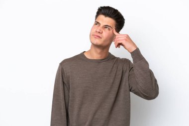 Beyaz fırında soyutlanmış genç beyaz bir adam deliliğin jestini yapıyor. Parmağını kafanın üstüne koyuyor.