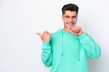 Beyaz fırında izole edilmiş yakışıklı beyaz adam bir ürün sunmak için yan tarafı işaret ediyor.