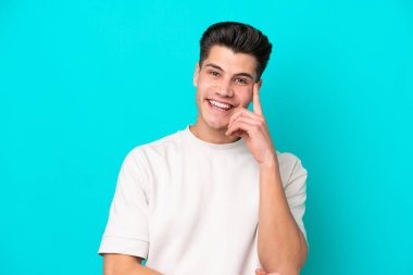 Genç, yakışıklı, beyaz bir adam mavi fırında yapayalnız gülüyor.