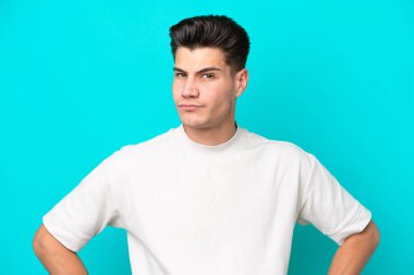 Genç, yakışıklı, beyaz bir adam, mavi fırında izole edilmiş, kızgın.