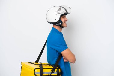 Beyaz arka planda, termal sırt çantalı beyaz tenli genç bir adam var.