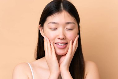 Young Chinese woman isolated on beige background . Portrait