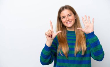 Beyaz arka planda izole edilmiş genç beyaz kadın parmaklarıyla yediyi saydı