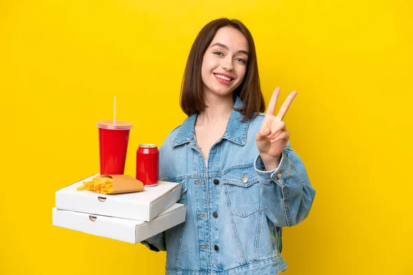 Young Ukrainian Woman Holding Fast Food Isolated Yellow Background Smiling — Stock Photo, Image