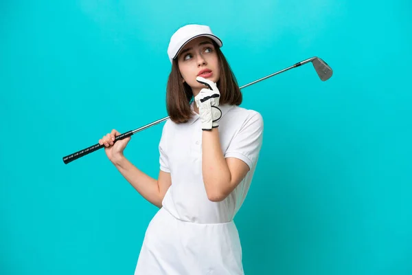 Junge Ukrainische Golferin Auf Blauem Hintergrund Isoliert Und Mit Zweifeln — Stockfoto