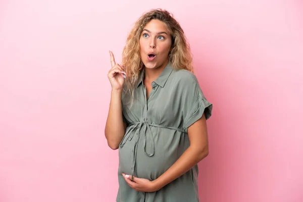 妊娠中や思考ピンクの背景に隔離された巻き毛の女の子 — ストック写真