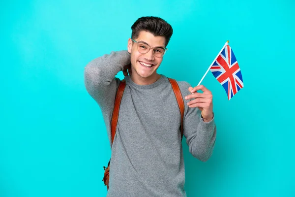 青い背景にイギリス国旗を掲げた若い白人男性が笑っている — ストック写真