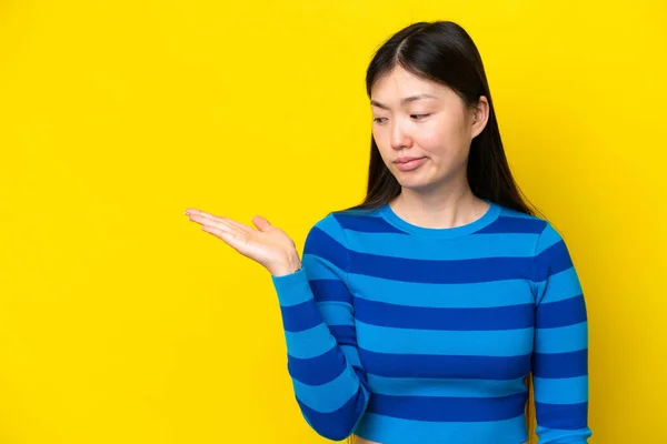 Young Chinese Woman Isolated Yellow Background Holding Copyspace Doubts — Foto Stock