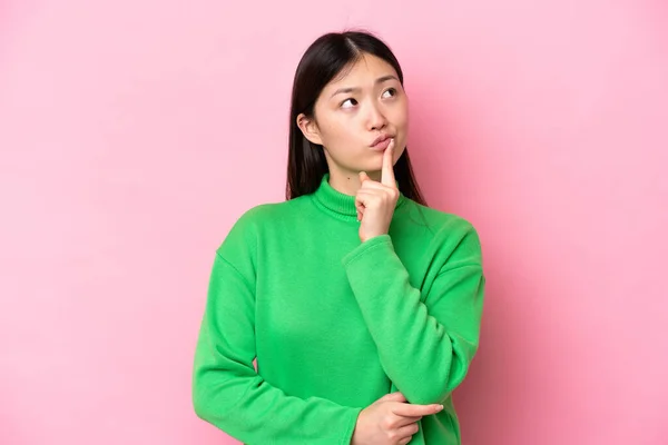 Young Chinese Woman Isolated Pink Background Having Doubts While Looking —  Fotos de Stock