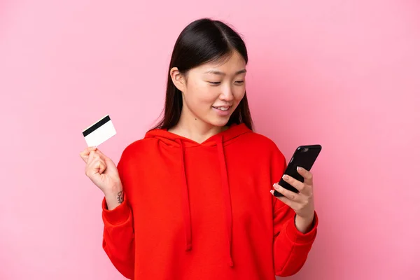 Fiatal Kínai Elszigetelt Rózsaszín Háttér Vásárlás Mobil Egy Hitelkártya — Stock Fotó