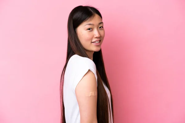 年轻的中国女人带着带着带着带着粉色背景的助听器 脸上带着快乐的表情 — 图库照片