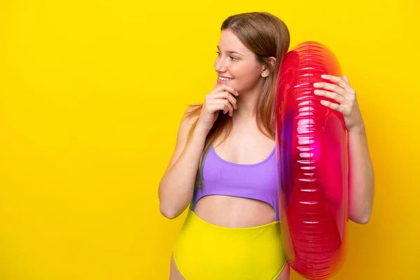 Young Caucasian Woman Holding Air Mattress Isolated Yellow Background Thinking — Stockfoto