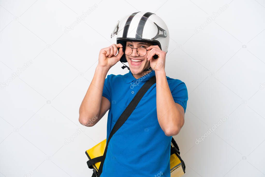 Young caucasian man with thermal backpack isolated on white background with glasses and surprised