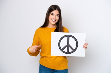 Genç Brezilyalı bir kadın beyaz arka planda izole edilmiş. Elinde barış sembolü olan bir pankart var.
