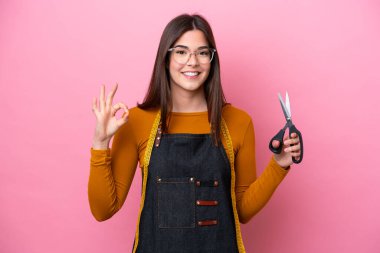 Pembe arka planda izole edilmiş genç Brezilyalı terzi kadın parmaklarıyla işaret veriyor.