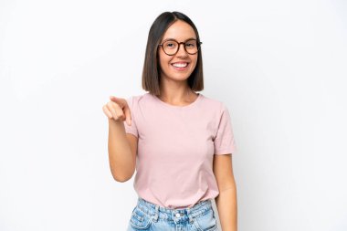 Beyaz arka planda izole edilmiş genç beyaz kadın şaşırmış ve ön tarafı işaret ediyor.