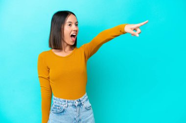 Mavi arka planda izole edilmiş genç beyaz kadın sunar ve davet eder.