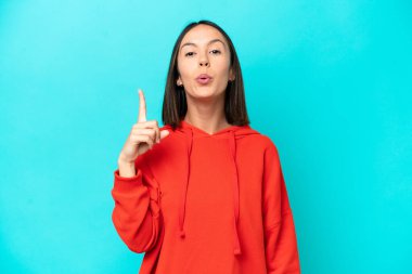 Mavi arka planda izole genç beyaz kadın bir şey fark etti ve çözüme niyetlendi.