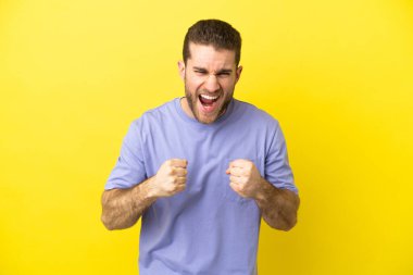 Handsome blonde man over isolated yellow background frustrated by a bad situation