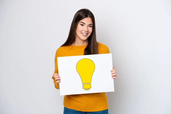 Young Brazilian Woman Isolated White Background Holding Placard Bulb Icon — Zdjęcie stockowe