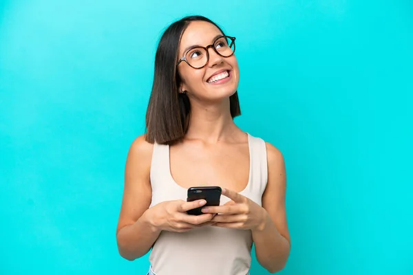 Giovane Donna Caucasica Isolata Sfondo Blu Utilizzando Telefono Cellulare Guardando — Foto Stock