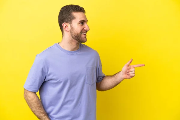 Handsome Blonde Man Isolated Yellow Background Pointing Finger Side Presenting — Photo