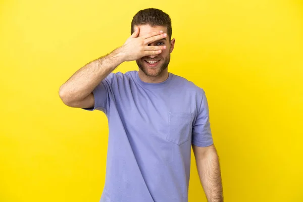 Handsome Blonde Man Isolated Yellow Background Covering Eyes Hands Smiling — Zdjęcie stockowe