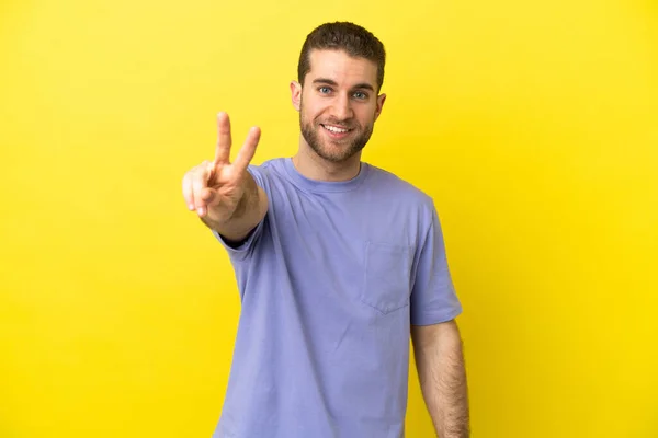 Handsome Blonde Man Isolated Yellow Background Smiling Showing Victory Sign — Zdjęcie stockowe